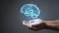 Glowing digital brain hologram floating above open human hands against dark background. Concept for artificial intelligence, neuroscience and innovation.
