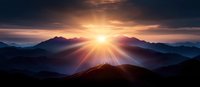 Dramatic panoramic mountain landscape at sunrise with sunburst breaking through clouds, casting golden rays across layered peaks in misty morning atmosphere.