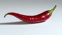 Fresh red chili pepper with green stem on white background, macro shot showing glossy texture and natural curves. Isolated food photography for culinary use.