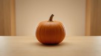 Fresh orange pumpkin with natural stem sits on wooden table against warm beige wall background for autumn harvest seasonal decoration and cooking.