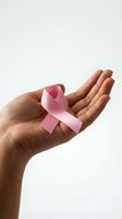 Pink ribbon in open palm symbolizing breast cancer awareness, hope and support for medical research and healthcare advocacy campaigns.