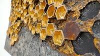 Rustic honeycomb pattern with golden hexagonal cells on dark textured surface, showing natural decay and weathering effects. Close up macro photography reveals organic texture.