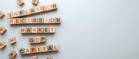Wooden blocks spelling inflation, recession, market, GDP, and capital on light background, representing economic concepts and financial crisis themes.