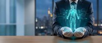 Professional businessman in dark suit holding glowing holographic human body with medical data visualization in modern office environment for healthcare technology.