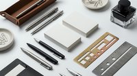 Elegant office supplies and stationery items arranged on white background including pens, rulers, ink bottle and paper blocks for professional workspace design.