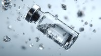 Clear glass vial with silver cap floating in water with splashing droplets and bubbles against light background.
