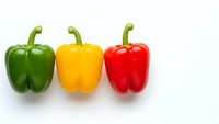 Three colorful bell peppers in green yellow and red arranged in row on white background isolated for healthy cooking and nutrition designs.