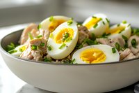 Fresh tuna salad with hard-boiled eggs and herbs in white bowl, healthy protein-rich meal for lunch or dinner recipes and cooking content.
