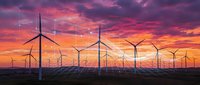 Wind turbines and solar panels generating renewable energy under dramatic pink and orange sunset sky creating sustainable power landscape.
