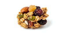 Homemade granola bar with mixed nuts, dried fruits, oats and seeds isolated on white background. Healthy snack for breakfast or energy boost during workout.