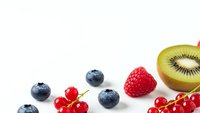 Fresh mixed berries and kiwi fruit on white background. Healthy organic food ingredients for smoothies, desserts and natural nutrition concepts.