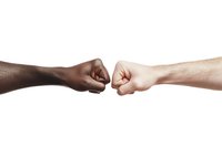 Two fists bumping against white background, showing unity and racial harmony. Isolated photo ready for design projects and marketing materials about diversity and teamwork.