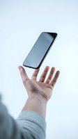 Caucasian male hand tossing modern smartphone with blank screen against white background, symbolizing technology, communication, and digital lifestyle for app development and mobile marketing.