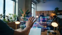 Programmer hand interacting with glowing digital workflow interface displaying development stages like design, code, and deploy in modern office workspace.