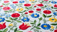 Colorful folk art embroidery pattern with roses, tulips and flowers on white fabric. Traditional Hungarian Kalocsa style floral design for textile crafts.