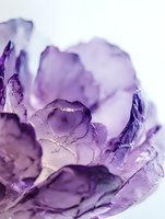 Purple amethyst crystal cluster with translucent faceted gemstone formations on white background for jewelry and healing stone designs.