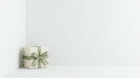Wrapped gift box with sage green ribbon bow on white surface against neutral background, suitable for holiday, celebration, and greeting card designs.