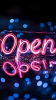 Glowing pink neon open sign with reflection and blue bokeh lights in dark background, creating atmospheric night business ambiance for retail and hospitality settings.