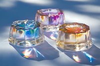 Colorful crystal prisms refracting light with rainbow spectrum effects against blue background, creating vibrant prismatic reflections.