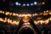 Hands forming heart shape against warm bokeh lights background creating romantic atmosphere for love and connection concepts.
