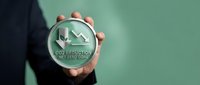 Businessman holding CO2 reduction net zero goal symbol with downward arrow graph representing carbon footprint decrease and environmental sustainability targets.