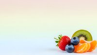Fresh mixed fruits including strawberry, blueberries, kiwi and orange slices on soft gradient background for healthy eating and nutrition concepts.
