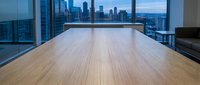 Empty modern office space with wooden flooring and floor-to-ceiling windows overlooking city skyline at dusk, suitable for corporate and commercial design projects.