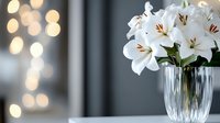 White lily flowers in crystal vase with warm bokeh lights creating elegant home decor atmosphere for interior design and floral arrangements.