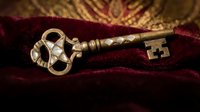 Antique brass skeleton key with pearl inlay resting on rich burgundy velvet fabric, evoking mystery, history, and luxury heritage themes.