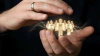 Hands of a Caucasian male protecting glowing golden human figures against dark background, symbolizing team care, community support, and workforce protection.