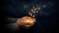 Hands cupping glowing magical sparks floating upward against dark moody background, mystical energy concept for spiritual wellness and inspiration designs.