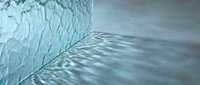 Melting glacier ice wall meets calm ocean water creating natural patterns and reflections in arctic seascape showing climate change effects.