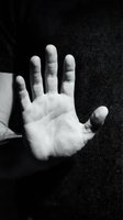 Child's open palm against dark textured background in monochrome. Suitable for parenting, childcare, protection, trust, and family-related design projects.