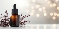 Brown glass dropper bottle with dried red berries against blurred bokeh background. Wellness and aromatherapy concept for natural cosmetics and essential oils.
