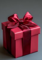 Elegant pink gift box with luxurious burgundy ribbon bow on dark background, creating sophisticated contrast for special occasions and holiday celebrations.
