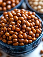 Fresh brown cowpeas in dark ceramic bowl, macro close up view of legumes showing natural texture and pattern, healthy organic protein source for cooking.