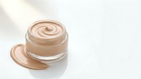 Luxury foundation cream in glass jar with smooth swirl texture on white background for skincare and makeup cosmetics advertising.