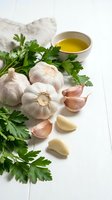 Fresh garlic bulbs and cloves with green parsley and olive oil on white wooden background for healthy cooking and Mediterranean cuisine preparation.