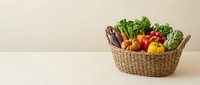 Fresh organic vegetables in wicker basket on neutral background for healthy eating and farm-to-table cooking concepts.