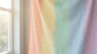 Soft rainbow gradient curtain with pastel colors creating dreamy atmosphere by bright window for home decor and interior design projects.