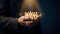 Businessman holding glowing light bulbs in open palm against dark background, symbolizing innovation, ideas, and business growth for corporate concepts.