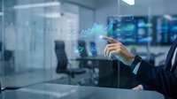 Businessman in dark suit analyzing financial growth chart with glowing holographic data visualization in modern office environment for business analytics and investment concepts.