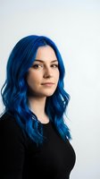 Young Caucasian woman with vibrant blue hair wearing black top against white background. Modern alternative style portrait for fashion and beauty concepts.