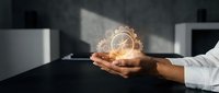 Business professional holding glowing lightbulb with gears symbolizing innovation and creative problem-solving in modern office environment.