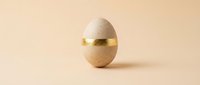 Elegant speckled egg with golden band on neutral background for luxury branding, Easter celebrations, and premium product packaging designs.