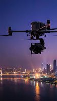 Professional drone with camera flying over illuminated city skyline at twilight for aerial photography and videography projects.