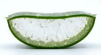 Fresh aloe vera leaf slice showing clear gel interior with water droplets on white background for natural skincare and wellness concepts.