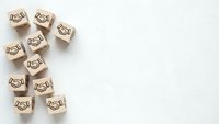 Wooden cubes with handshake icons arranged on white background representing business partnership, teamwork and cooperation concepts for corporate design.