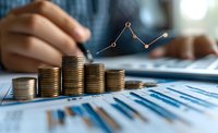 Stacks of gold coins with rising financial graph and business charts in background, hands analyzing investment data on laptop, showing growth trend analysis.