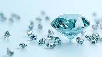 Sparkling aqua blue diamond surrounded by smaller scattered gems on light background, luxury jewelry concept with soft selective focus and reflective surface.